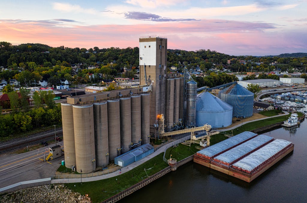 Aerial View of an Industry with Grain Elevators near a Reservoir