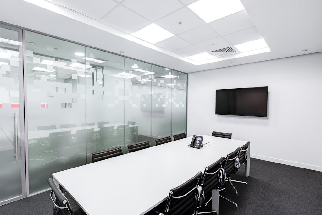 Rectangular White Table With Rolling Chairs Inside Room