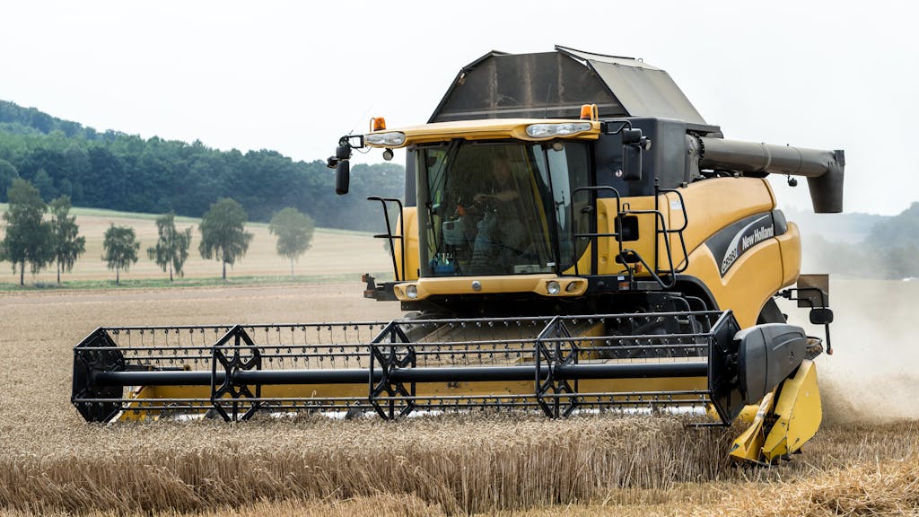 Man in Combine Harvester in Field